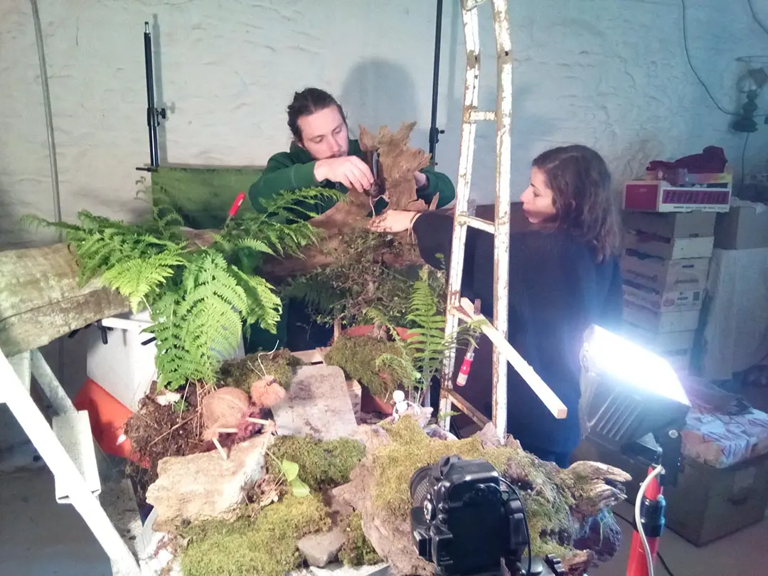 Deux personnes installent le décor de tournage des Voyages de Nym