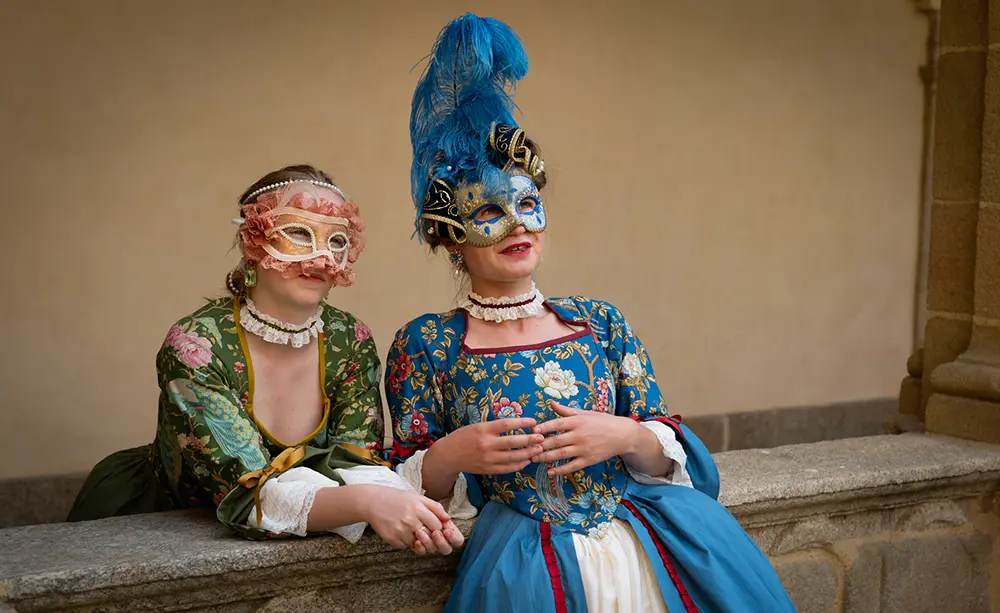 Captation de spectacle vivant deux femmes masquées en robes d'époque accoudées à un muret